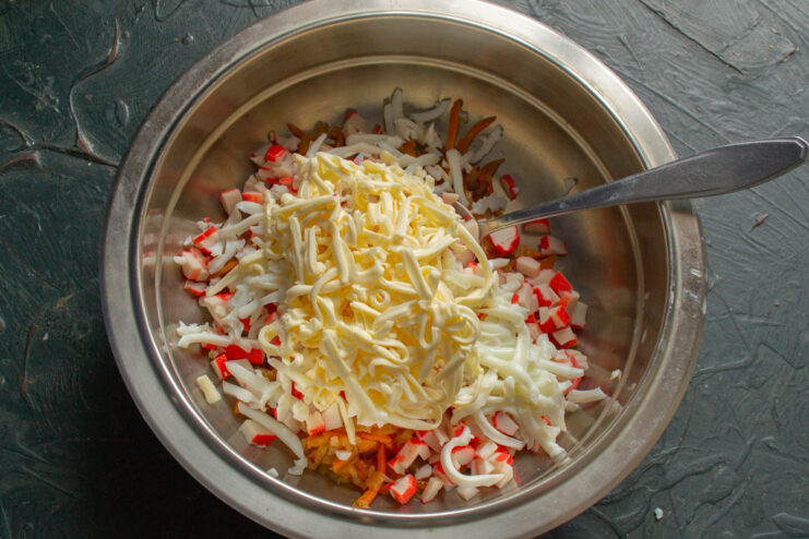 Adding Grated Egg Whites for Texture and Protein Adding grated hard-boiled egg whites to the salad bowl with other ingredients.