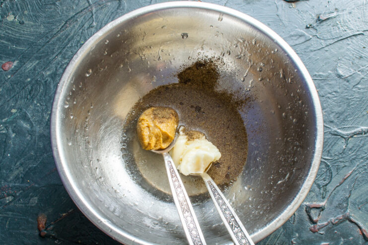 Creating the flavorful honey-mustard sauce. A small bowl with honey, mustard, and spices being mixed for the sauce.