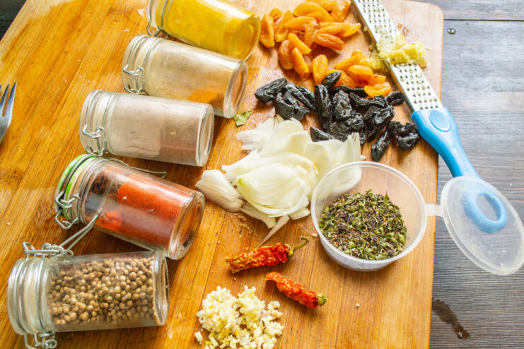 Aromatic Spices and Dried Fruits for the Sauce A collection of spices, dried apricots, prunes, onion, and garlic ready for the recipe.