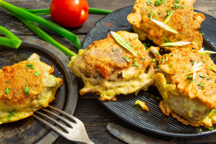A plate of golden-brown chicken thighs in a crispy rice batter, ready to be served.