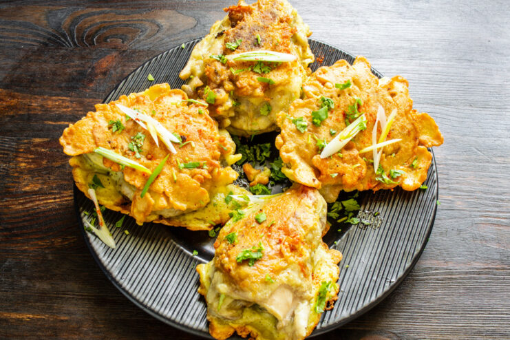 Fried chicken thighs resting on a paper towel to absorb excess oil.