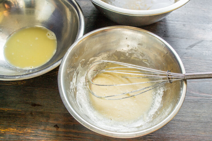 Rice flour being poured into a bowl with whisked eggs.