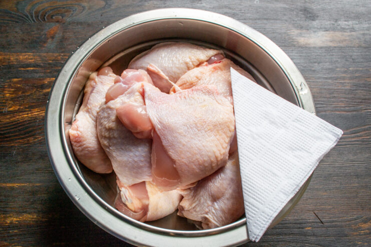 Patting Chicken Dry for a Crispier Skin Patting raw chicken thighs dry with paper towels.