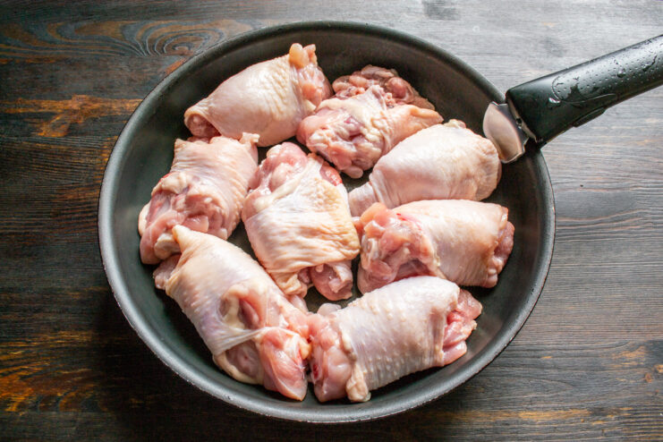 Searing Chicken Thighs for a Golden-Brown Crust Placing chicken thighs skin-side down into a hot skillet.