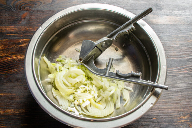Creating the Aromatic Base for the Tomato Sauce A bowl with finely chopped onion and minced garlic.