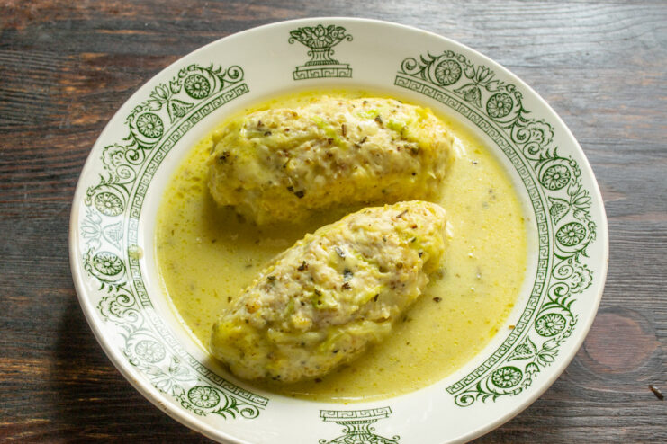 A complete and balanced meal in one dish A close-up of a finished chicken and quinoa patty in a creamy sauce, served in a bowl.