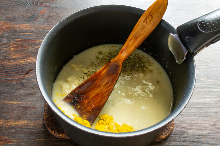 Starting the creamy sauce by melting butter A piece of butter melting in a saucepan on the stove.