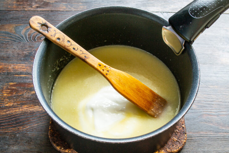 Step 5: Making a Roux for the Cream Sauce Making a roux by mixing flour and melted butter with a spatula in a heavy-bottomed pot.