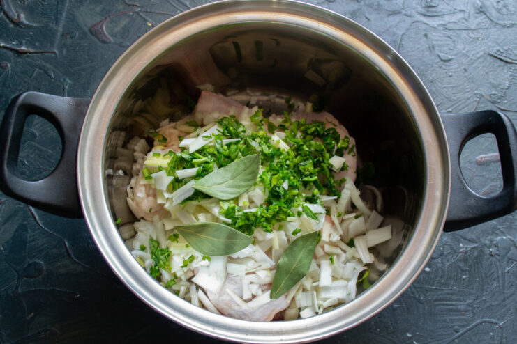 Preparing fresh parsley to add herbal notes to the soup A bunch of fresh parsley being finely chopped on a cutting board.