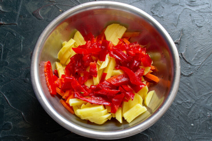 Dicing sweet bell pepper to add color and sweetness A red sweet bell pepper being finely chopped on a cutting board.