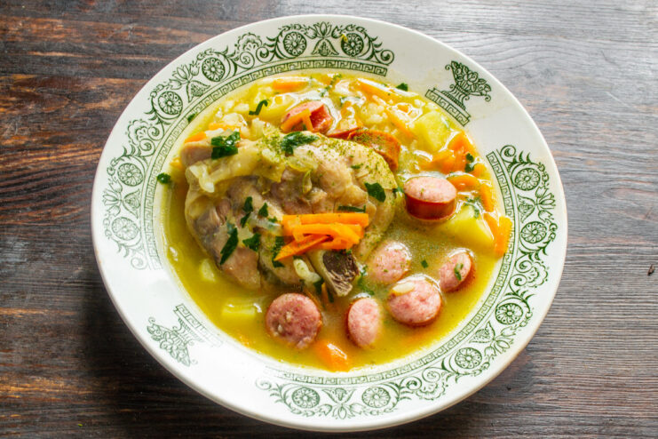 Serving the Delicious Homemade Chicken and Sausage Soup A bowl of hot chicken soup with rice and sausages, ready to be served.
