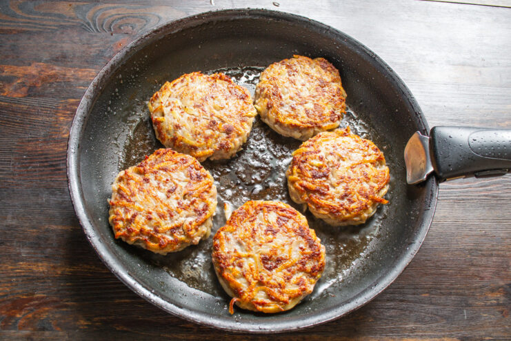 Getting the Perfect Crust: Frying the Other Side Kolduny patties being flipped with a spatula in a skillet, showing a golden-brown crust.