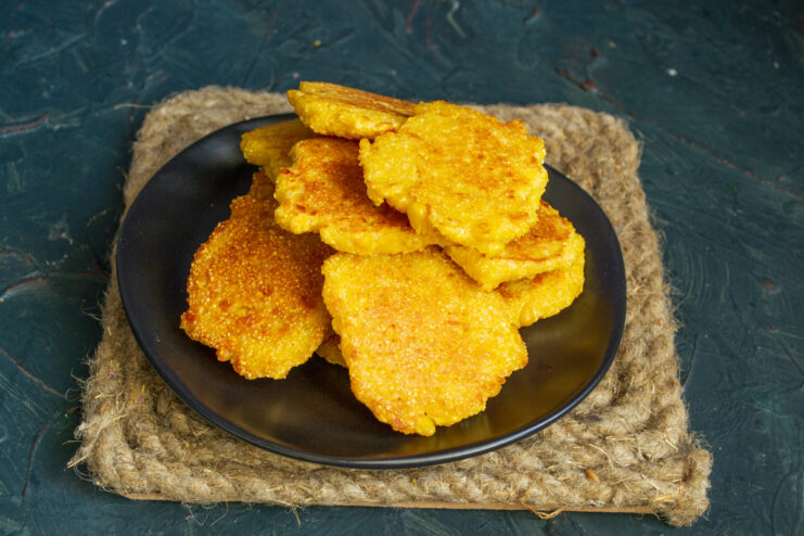 Serving hot and fresh corn fritters A stack of freshly cooked hot corn fritters on a plate.