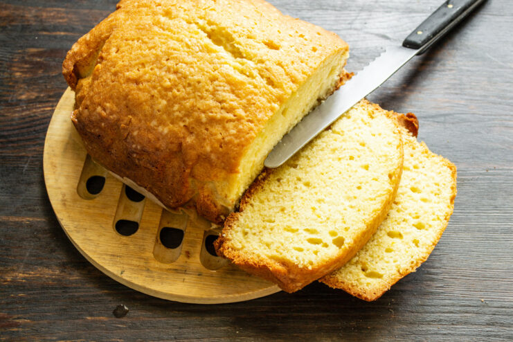 Cooling the freshly baked pound cake before serving. A freshly baked lemon pound cake cooling on a wire rack, sliced to show the texture.