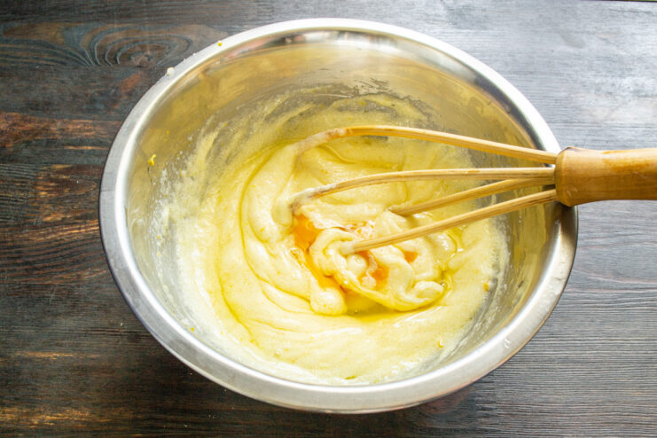 Tip: How to fix curdled cake batter. Cake batter in a bowl that has slightly curdled, with a tip to add flour.