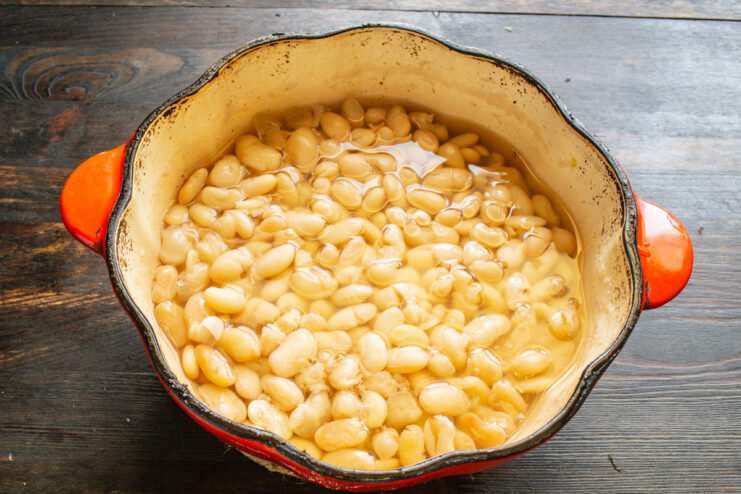 Step 1: Soaking and Cooking the White Beans for Lobio White beans being covered with water in a stainless steel pot.