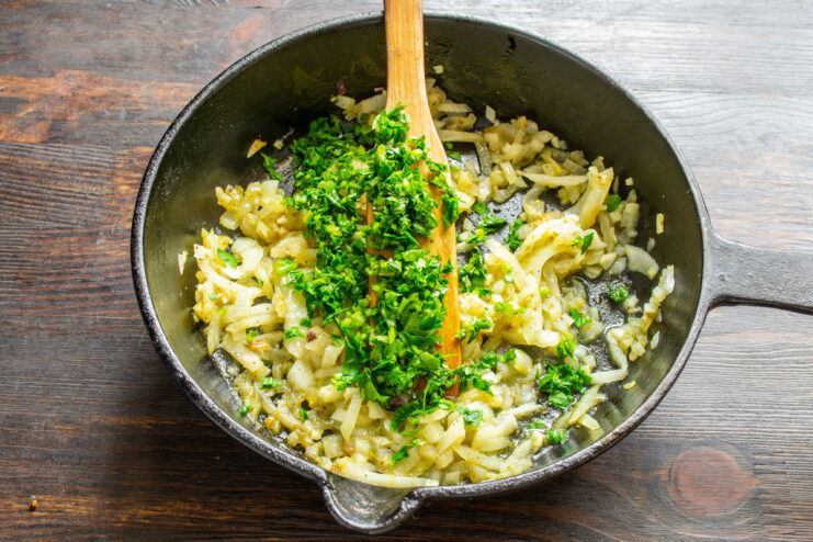 Adding Fresh Herbs for Authentic Flavor A bunch of fresh cilantro being finely chopped on a cutting board.