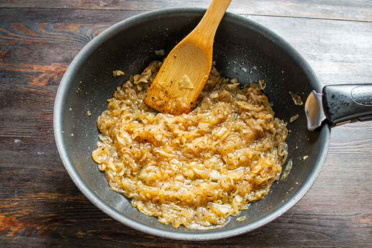 Reducing the Wine and Caramelizing Onions Onion jam simmering in a skillet after adding red wine, reducing the liquid.