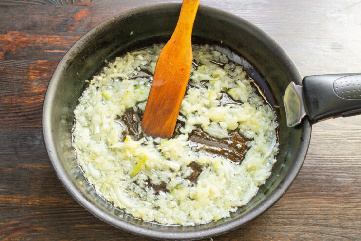 Sautéing Onions to Build Flavor for the Sauce Chopped onions and garlic sautéing in butter in a skillet.
