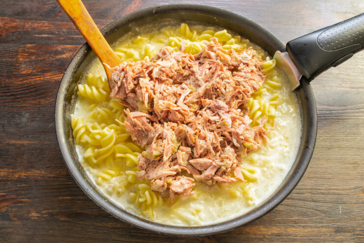Mixing in the Shredded Turkey Shredded turkey being added to the pasta and cream sauce mixture.
