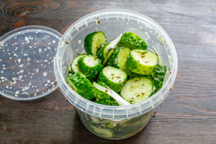 Shaking the Jar to Mix Ingredients Thoroughly Shaking a sealed container to evenly distribute salt and spices over the cucumbers.