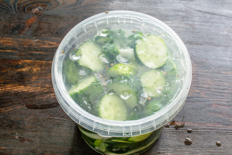 Letting the Cucumbers Ferment in a Warm, Dark Place A sealed jar of cucumbers placed in a dark cupboard to ferment for three days.