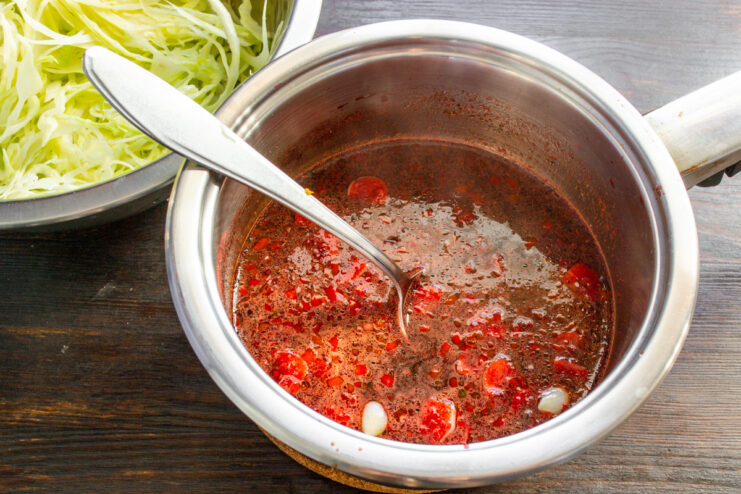 Bringing the Marinade to a Boil The dark red marinade boiling in a saucepan on the stove.