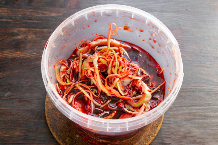 Storing the Cabbage to Marinate The finished Korean-style marinated cabbage packed into a glass container for refrigeration.