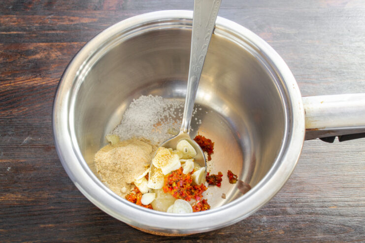 Seasoning the Marinade with Salt and Ginger Adding sea salt and ginger powder to the saucepan with other marinade ingredients.