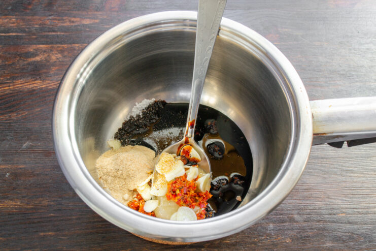Adding Dark Soy Sauce for Umami Flavor Pouring dark soy sauce into the saucepan to create the marinade base.