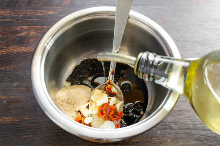 Incorporating Oil into the Marinade Adding vegetable oil to the marinade mixture in the saucepan.