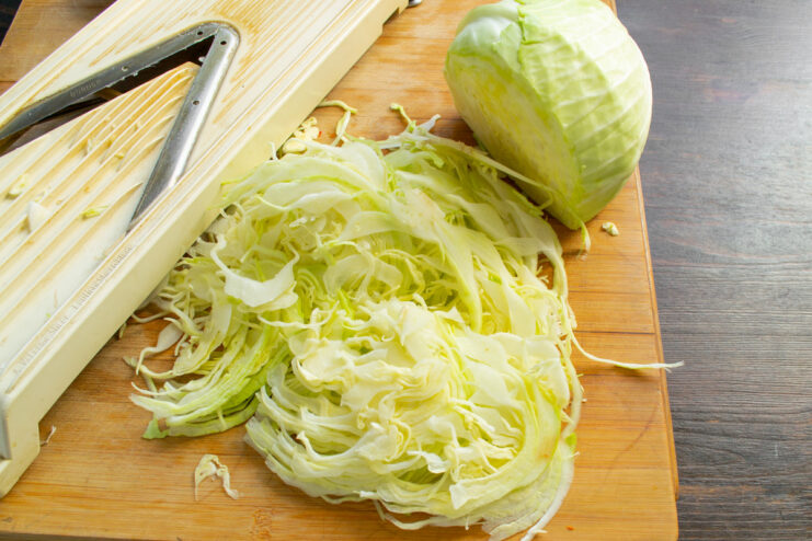 Shredding Cabbage for the Salad Shredding white cabbage into fine strips using a mandoline slicer.
