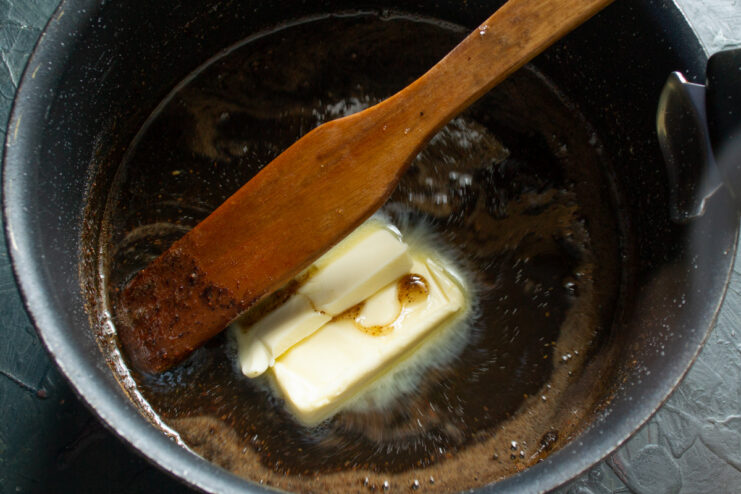 Combining honey and molasses with the hot sugar syrup to create a rich, flavorful base. Adding dark molasses and buckwheat honey to the hot sugar syrup in a saucepan.