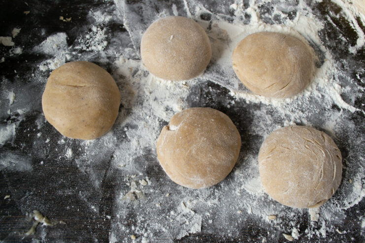 Portioning the gingerbread dough to ensure evenly sized cookies. Small, equal-sized portions of gingerbread dough on a floured surface.
