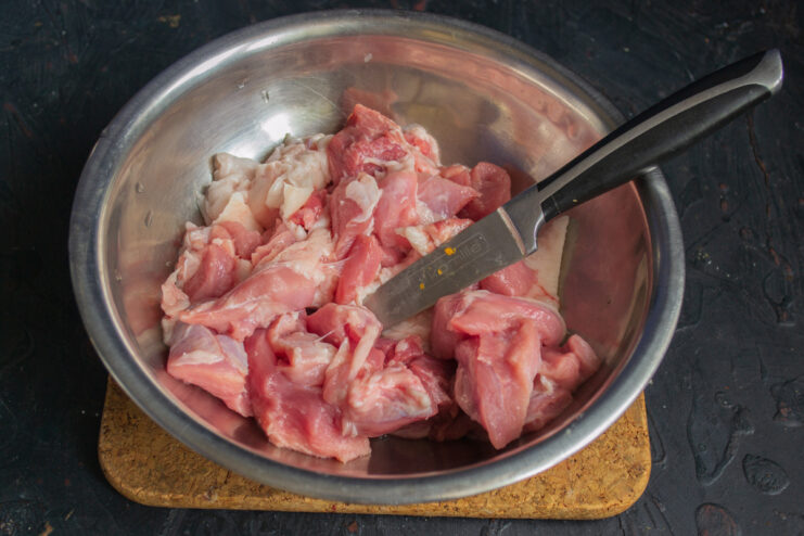 Preparing the Meat: Dicing Pork and Fat for Juicy Meatballs Close-up of diced pork and finely chopped pork fat on a cutting board, ready for grinding.