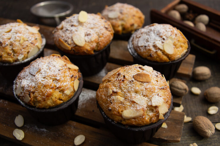 A plate of freshly baked carrot muffins with nutmeg, dusted with powdered sugar.