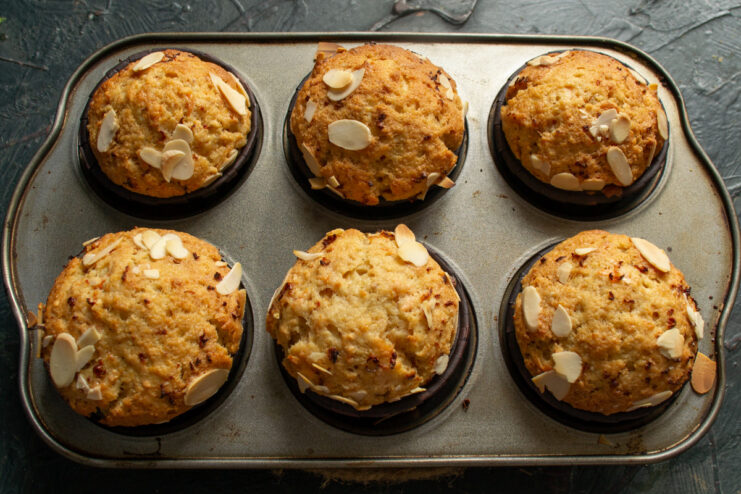 Baking the carrot muffins until golden brown. A muffin tin with carrot muffins baking inside a hot oven.