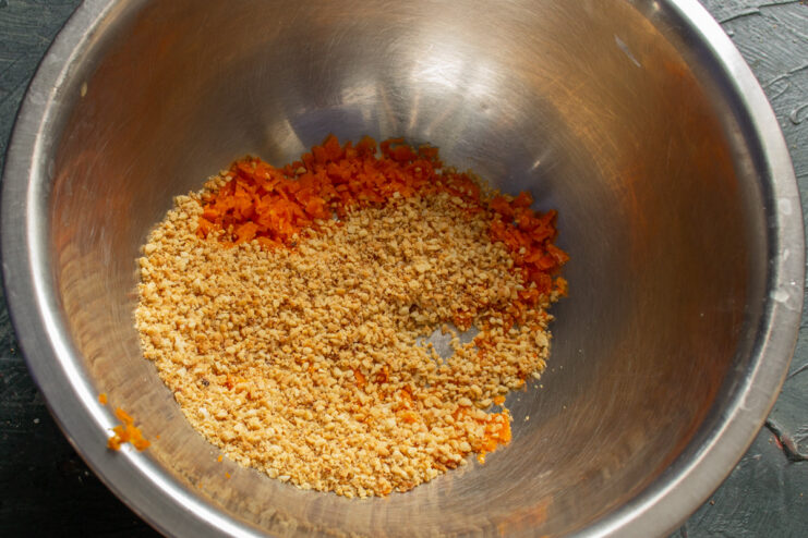 Combining dry ingredients: ground nuts and orange zest. A bowl containing orange zest and finely ground almonds.