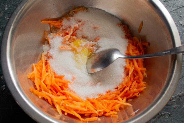 Sweetening the muffin batter with sugar. Granulated sugar being poured into a mixing bowl.