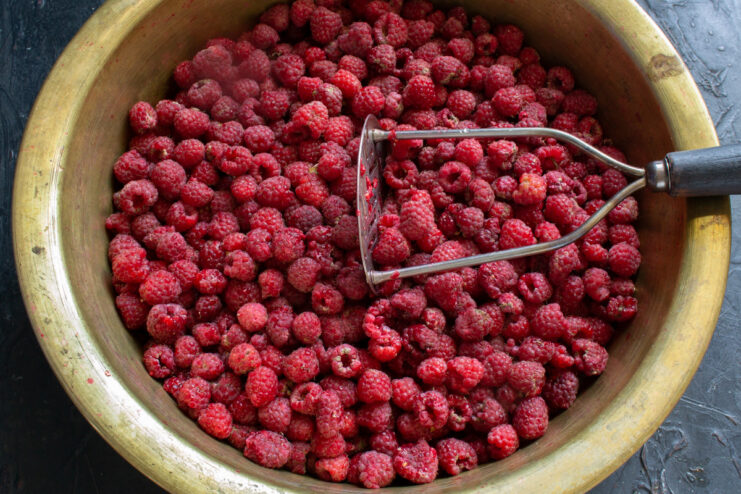 The Importance of Fresh Berries for Juice Making A close-up of a bowl filled with fresh, ripe raspberries ready for making juice.