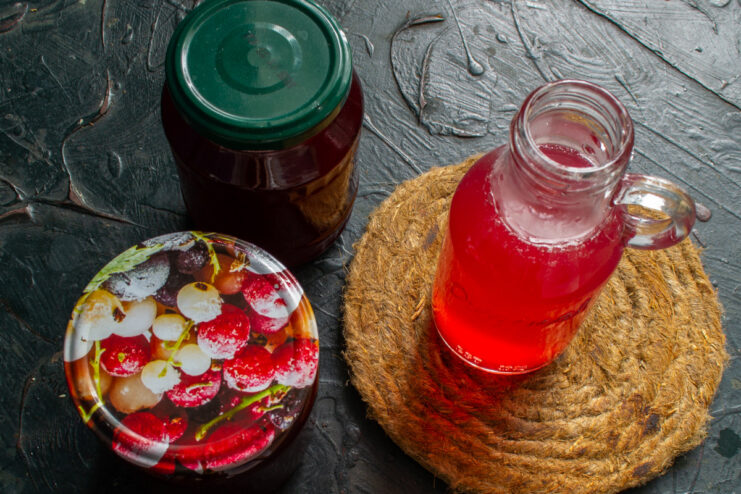Proper Storage for Homemade Canned Raspberry Juice Sealed jars of homemade raspberry juice cooling upside down on a cloth after pasteurization.