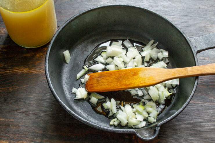 Sautéing Onions Until Soft and Fragrant Diced onions being sautéed until soft in a frying pan.