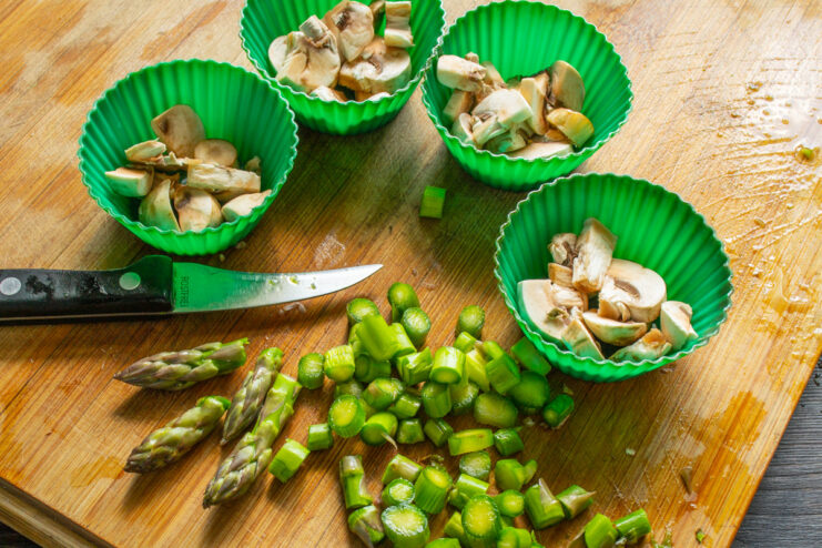 Prepping Asparagus: Finely Chopping the Stalks Peeled asparagus stalks being finely chopped on a cutting board.