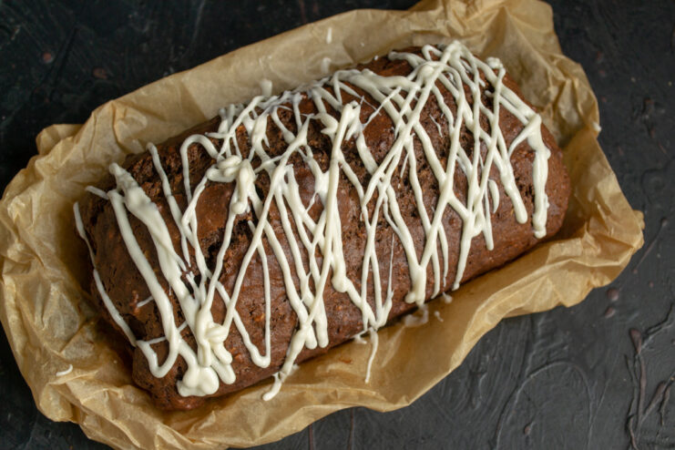 Creating a beautiful white chocolate drizzle for the cake. Drizzling melted white chocolate over the cooled nut and cocoa cake.