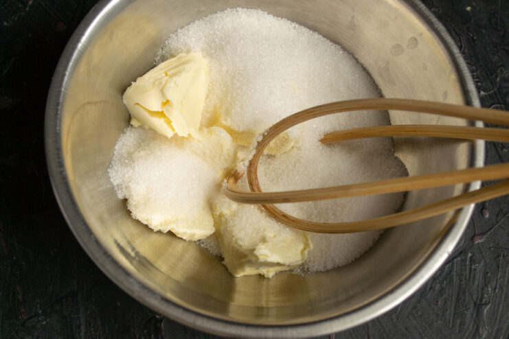 Starting the batter for the nut and cocoa cake. Ingredients for the cake batter, including butter and sugar, in a mixing bowl.