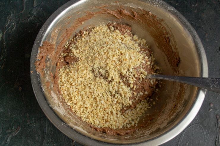 Using a food processor to chop the toasted almonds. Toasted almonds being chopped into coarse crumbs in a food processor.