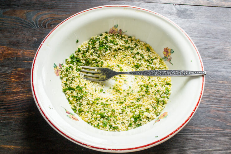 Creating a Flavorful Panko Coating with Herbs and Spices Panko breadcrumbs being mixed with chopped parsley and yellow turmeric powder.