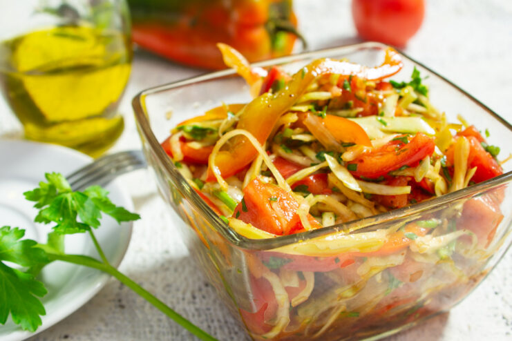 A white bowl filled with a colorful vegetable salad with honey dressing, ready to be served.