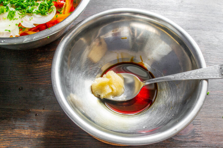 Ingredients for the honey dressing, including honey and soy sauce, in small bowls.