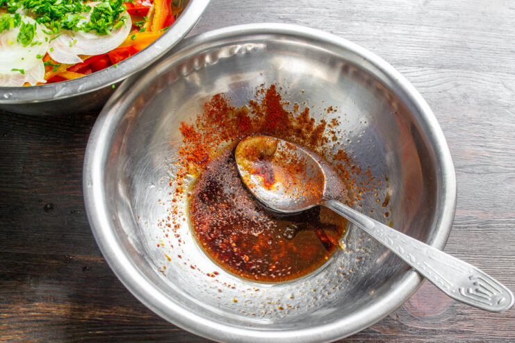 Spices, including paprika, being added to the salad dressing mixture.